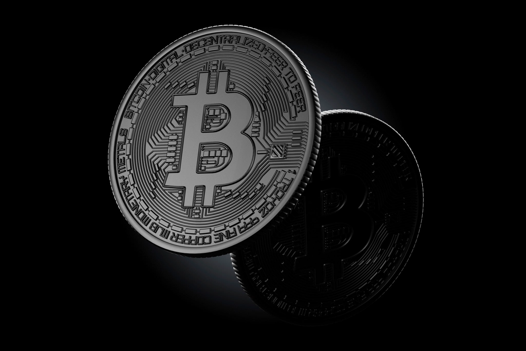 A physical bitcoin token on a dark surface